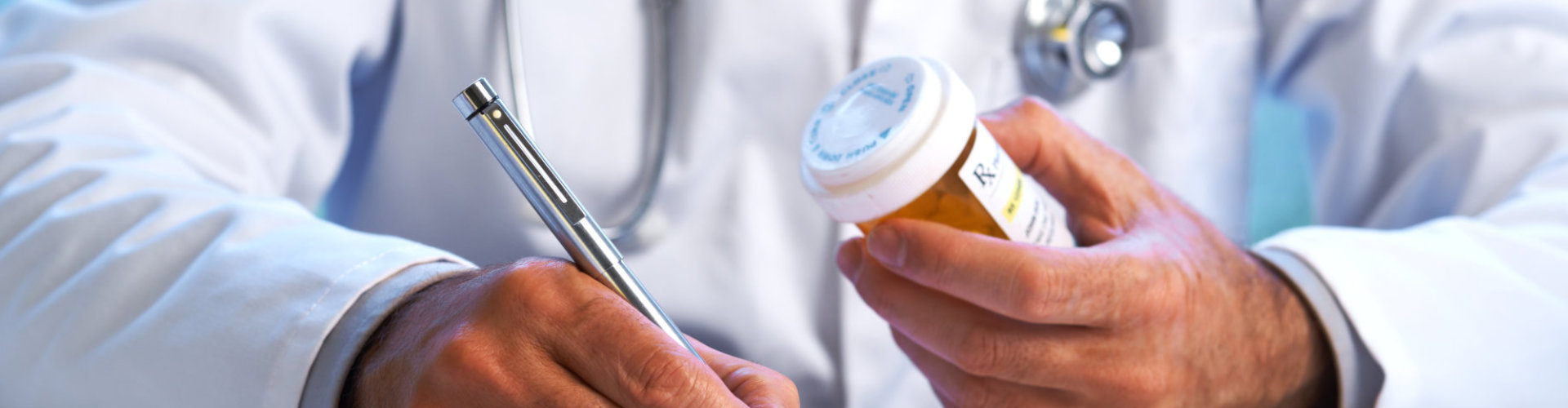 hands of a medical staff holding a pen and a medicine